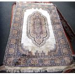 An Indian rug, the ivory field with an oblong grey medallion, complementary border, 191cm x 120cm,