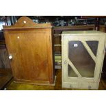 A pine wall cupboard with glazed door and another with panelled door.