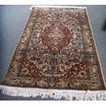 An Indian silk rug, the ivory field with a deep orange floral medallion, matching spandrels,