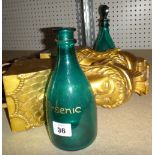 Two green mallet-shaped decanters and an associated stopper,