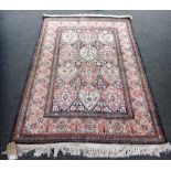 An Indian rug, the black field with three columns of ivory and pink lobed medallions,