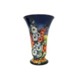 A Moorcroft 'Hollyhock' tapering vase, limited edition 39/250, blue ground, 23cm high, boxed.