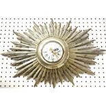 A French silvered, carved wood sunburst wall clock, 20th century, with enamel dial and carved body,