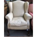 A mid 18th century style wingback armchair on stained beech claw and ball feet.