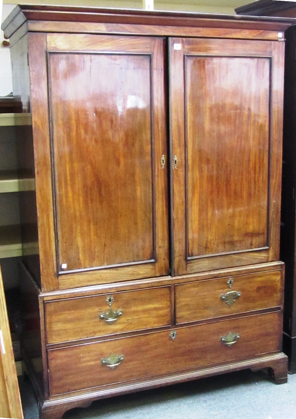 A George III mahogany linen press, the pair of panel doors over two short and three long drawers,