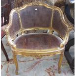 A Louis XV style gilt framed double bergere tub chair with bow seats on scroll supports.