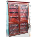 A 19th century mahogany shallow double height glazed four door display cabinet on plinth base,