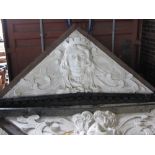 A pair of 19th century over doors, each of triangular form, relief cast with female masks,