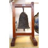 A reproduction bronze bell held in a wooden frame, 20th century,