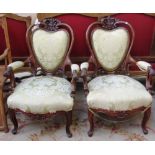 A pair of Victorian mahogany framed open armchairs with pierced and carved frames and serpentine