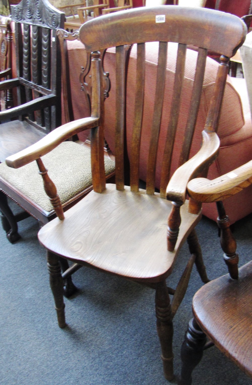 A Victorian beech and elm kitchen Windsor open armchair on turned supports.