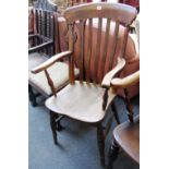 A Victorian beech and elm kitchen Windsor open armchair on turned supports.