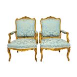 A pair of gilt framed open arm fauteils of Louis XV style with serpentine seat,