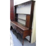 An 18th century oak dresser, the open three tier plate rack with pair of cupboards,