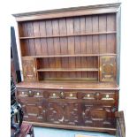 A large oak dresser, the enclosed three tier plate rack with pair of cupboards,