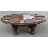 A 19th century carved oak Lazy Susan, the circular top with eight leather inset dished wells,