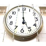 A modern circular wall clock with matte silvered circular frame,