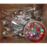 A quantity of silver plated flatware and a circular box containing marbles.