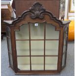 An 18th century Dutch oak hanging cupboard with bonnet top and swept back sides, 78cm wide.