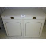 A cream painted sideboard with two doors