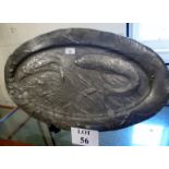 A large oval pewter dish depicting fish