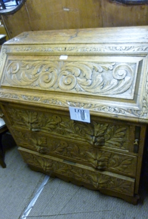 A late Victorian carved oak bureau with