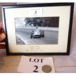 An old framed photograph of Juan Fangio