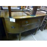 An Edwardian mahogany bow fronted sideboard with central drawers flanked either side by cupboards