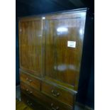 A George III mahogany linen press with double doors (later shelves) over two short and two long