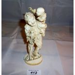 An oriental ivory carving of an old man carrying a child signed est: £120-£160