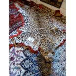 An early 20c leopard skin rug est: £500-£800