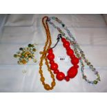 A collection of three necklaces and a small bag of beads est: £20-£30