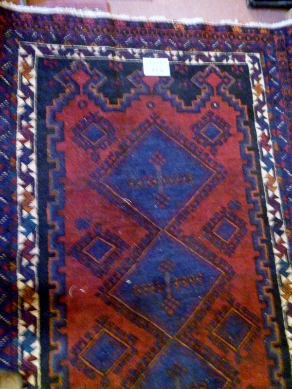 A Persian rug on blue ground (200 x 134 cm approx) est: £55-£85