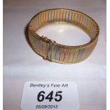 A 9ct gold banded bracelet in three coloured gold est: £150-£250