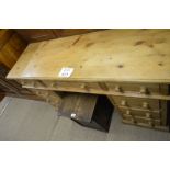 A pine pedestal writing desk with nine drawers est: £60-£80