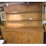 A 19c pine dresser with a boarded plate rack with three central drawers flanked either side by