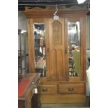 An Art Nouveau satinwood double wardrobe with a carved central panel depicting musical instruments