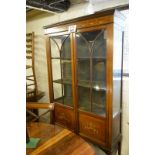 An Edwardian mahogany inlaid display cabinet with two glass doors with painted garlands to base