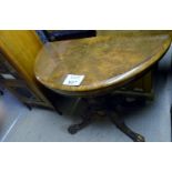 A Victorian walnut demi lune turnover card table with a turned column base and splayed legs c1880