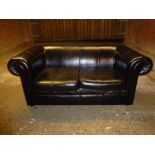 A two seater brown leather Chesterfield sofa in good condition est: £250-£450