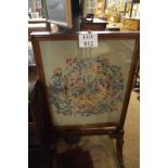 A 19c rising fire screen with a needlework panel over splayed legs and brass coasters est: £50-£80