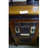 An Edwardian walnut music cabinet with a gallery rail over a segmented mirror door est: £40-£60