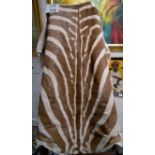 A zebra skin rug with felt backing est: £100-£150