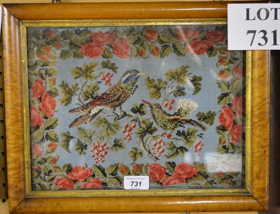 A maple framed and glazed woolwork embroidery of two birds in a rose-blossom border,