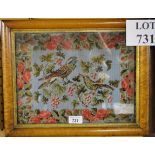 A maple framed and glazed woolwork embroidery of two birds in a rose-blossom border,