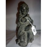 A metal figurine of a young girl praying