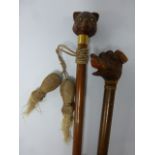 Two walking canes with cat and dog knops