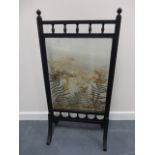 An ebonised fire screen, the clear glass
