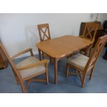 An oak effect extending dining table with four associated light oak chairs (2+2carvers) with