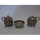 Two Continental white metal mustard pots with embossed floral and foliate decoration,